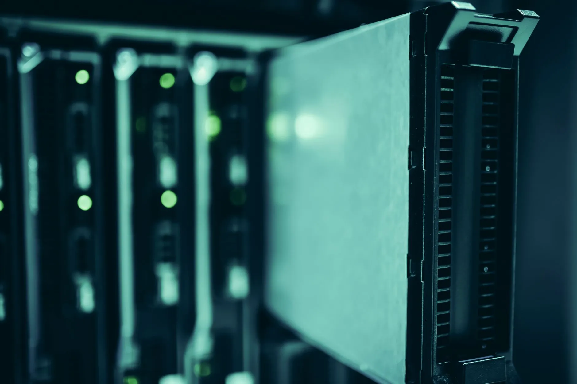 Server racks with status lights in a dark data centre